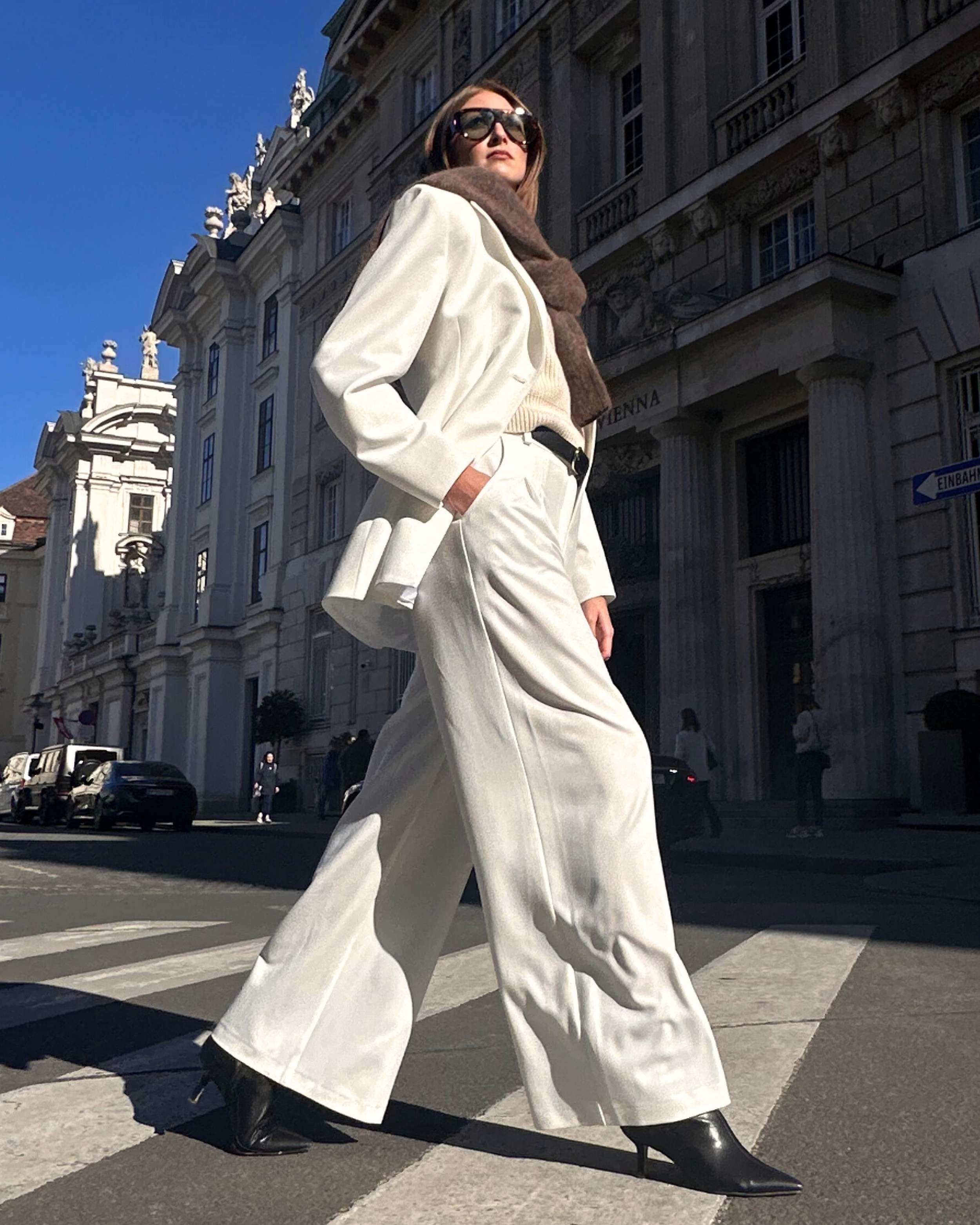 Model wearing THÉFI Dione high-waist wide-leg trousers in cream.