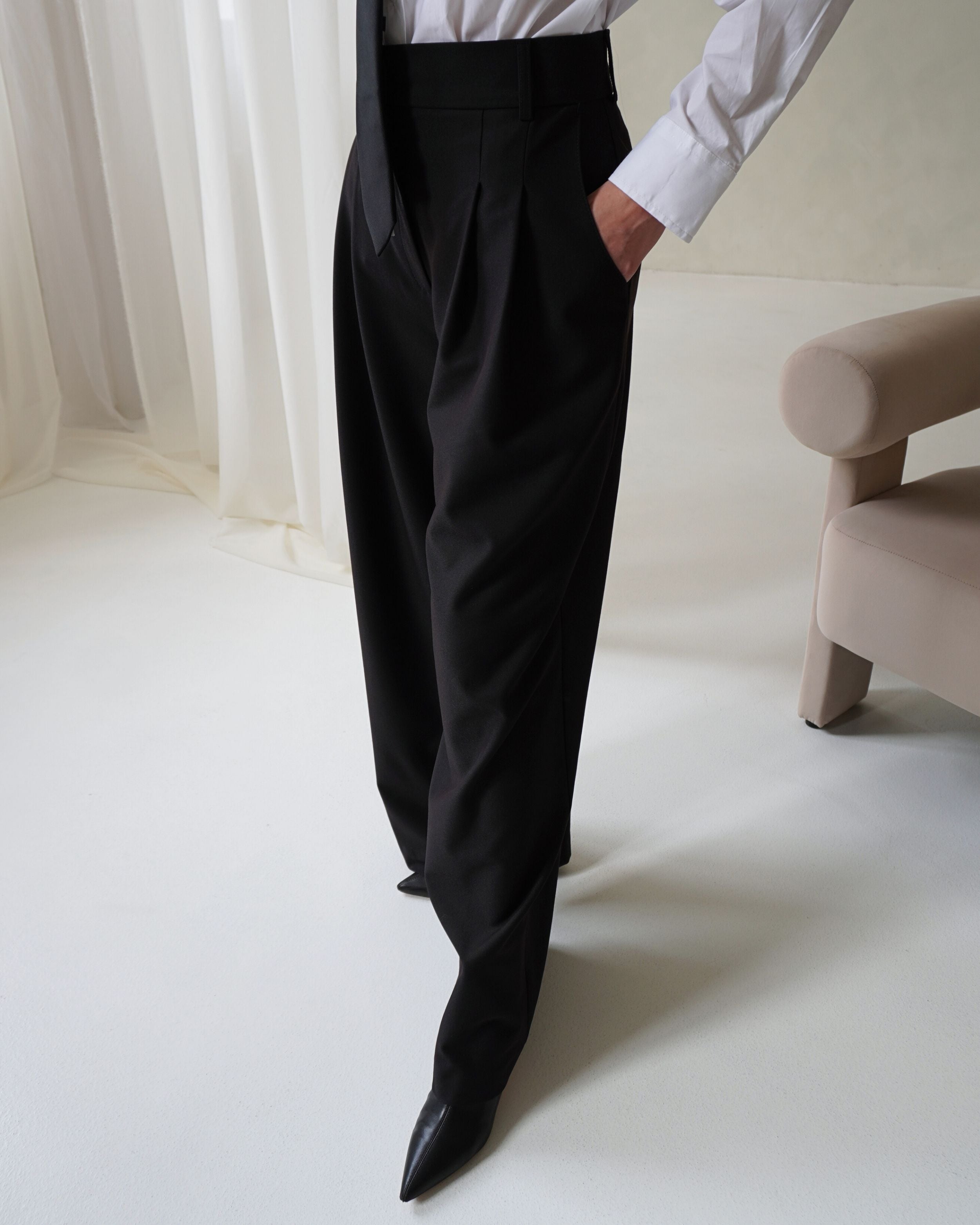Detail of high-waist tailored Dione trousers in black.