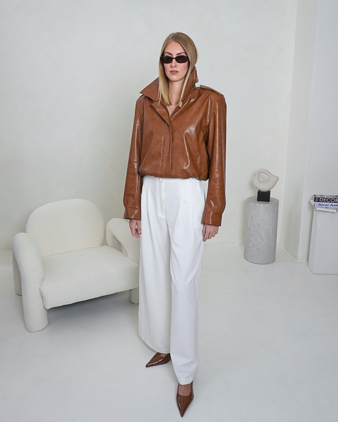 Brown HERA Faux Leather Jacket by THÉFI styled with Dione cream wide-leg trousers, showing the jacket's cropped silhouette and structured shoulders.