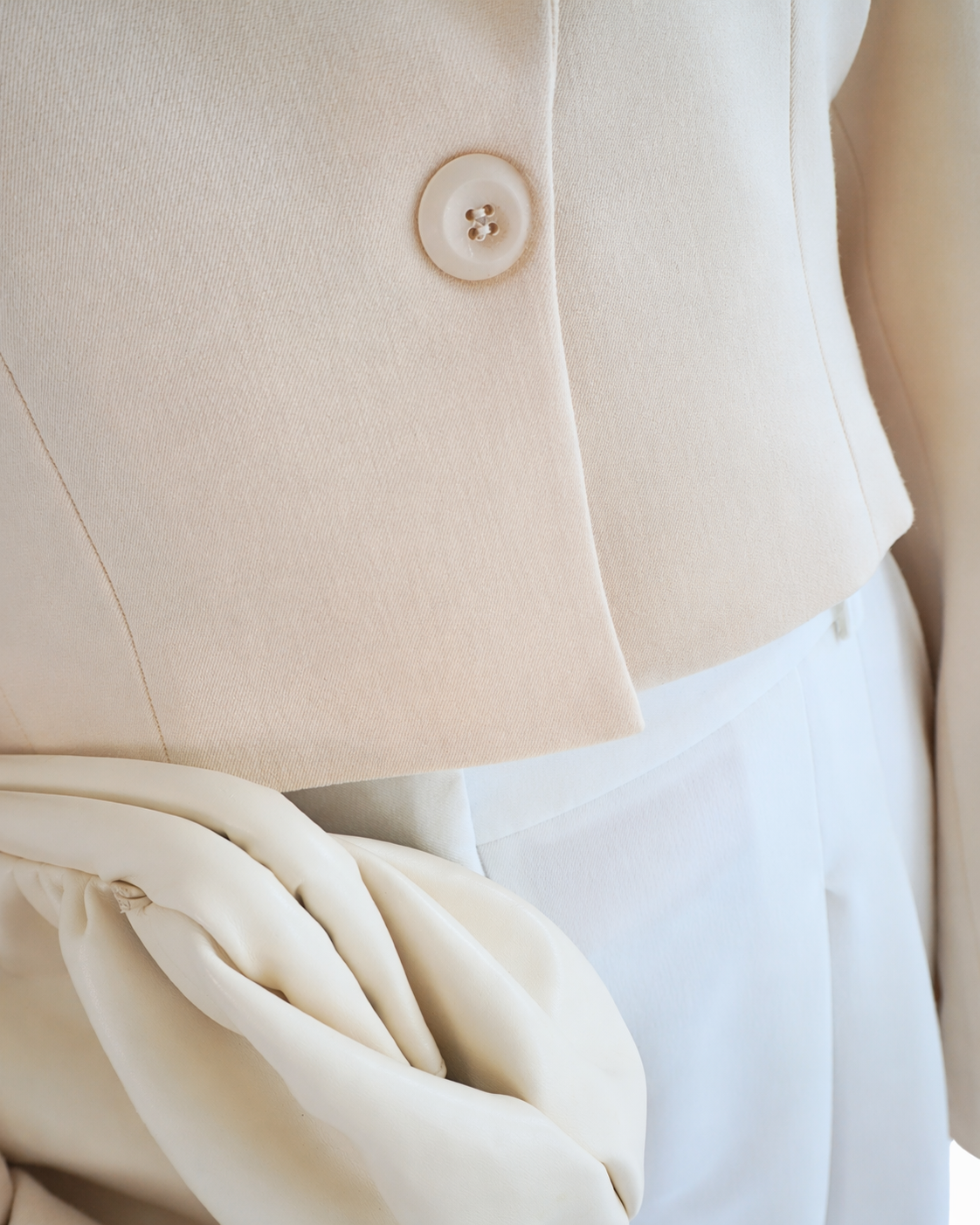 Button detail on beige apricot crop blazer THÉFI highlighting minimal design and craftsmanship