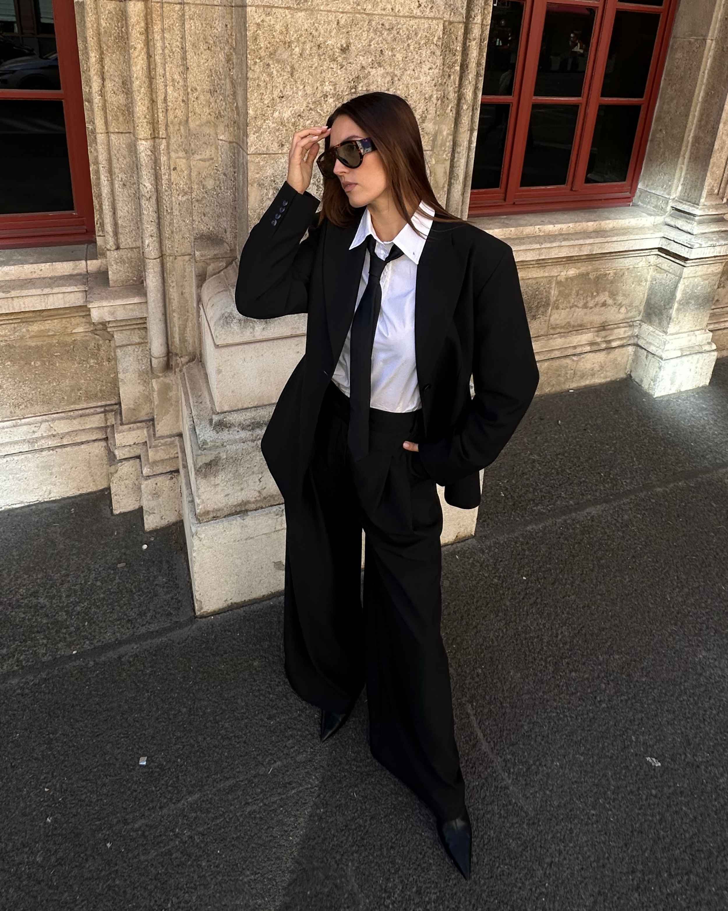 Model wearing THÉFI Dione high-waist wide-leg trousers in black.