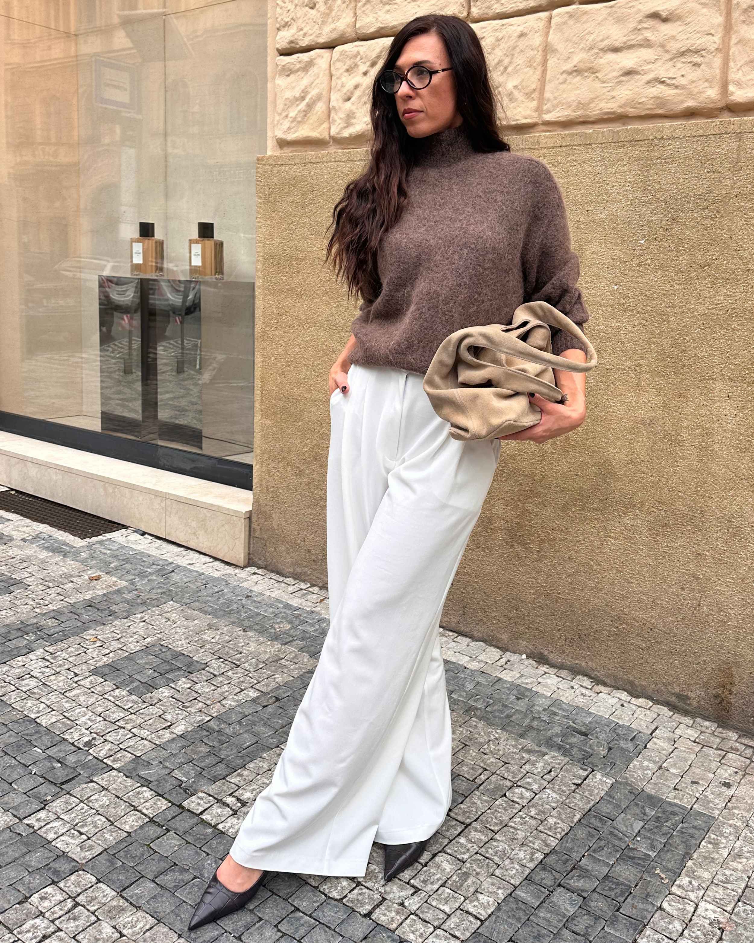 Model wearing THÉFI Dione high-waist wide-leg trousers in cream.