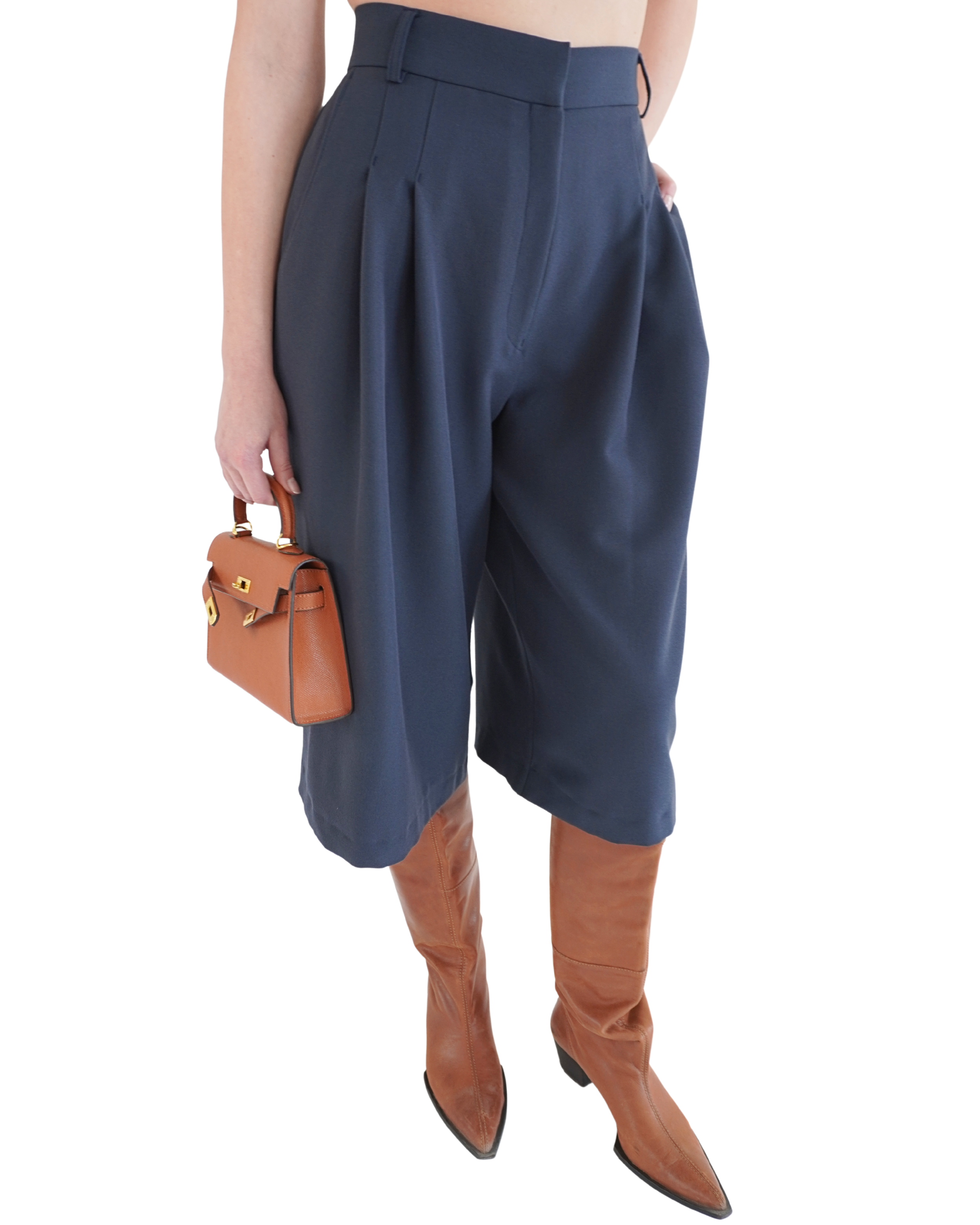 Front angle view of navy Delia bermuda shorts highlighting movement and fluid tailored silhouette THÉFI
