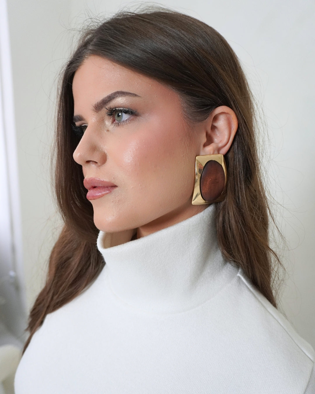 Close-up of the cream SELENE Turtleneck by THÉFI, highlighting its softly structured high stand collar, smooth knit fabric and fitted shoulder line.